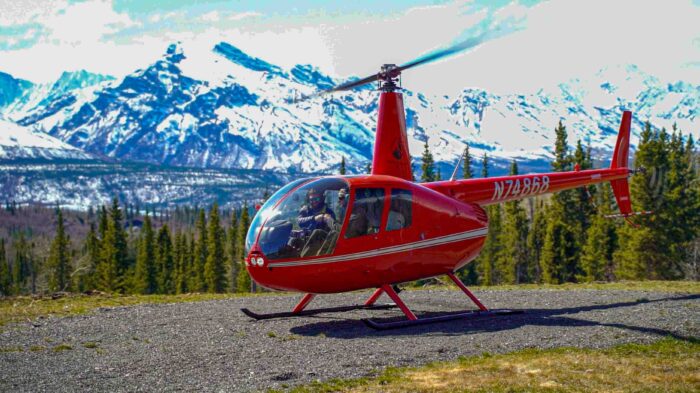 Red helicopter in front of snowy mountains in Alaska
