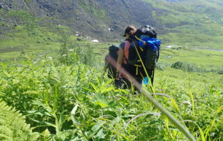 backpackers in green field