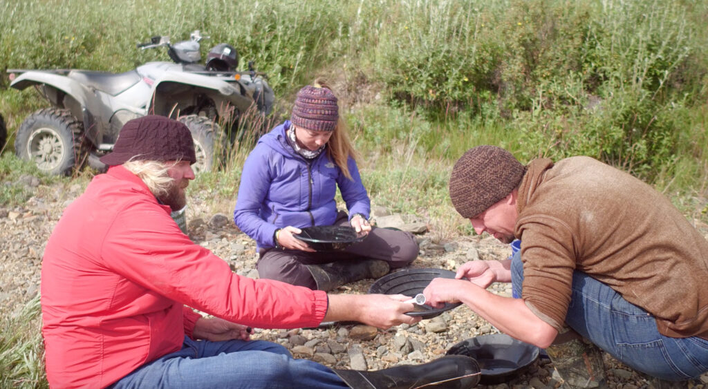 people looking over gold sifting pan