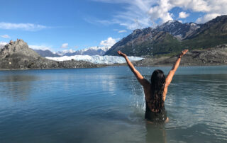 person swimming in glacier water